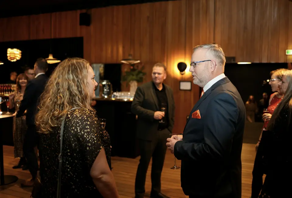 Executivos em networking durante evento corporativo